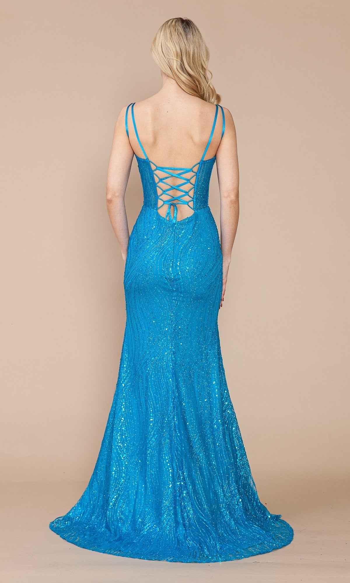 A woman in the Sequin-Print Sheer-Waist Long Prom Dress 9400, featuring bright blue sequins, a floor-length cut, spaghetti straps, and a lace-up back, stands against a neutral background.